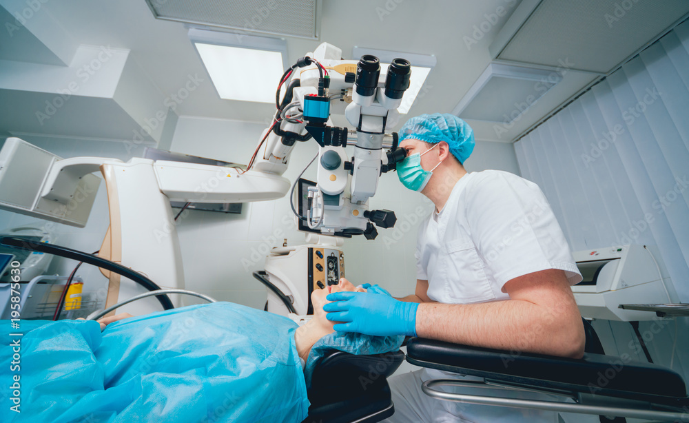 Eye surgery. A patient and surgeon in the operating room during ophthalmic surgery. Vision correction Eye surgery. A patient and surgeon in the operating room during ophthalmic surgery. Vision correction