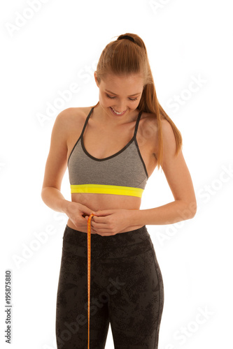 Beautiful fit woman measures waste isolated over white background