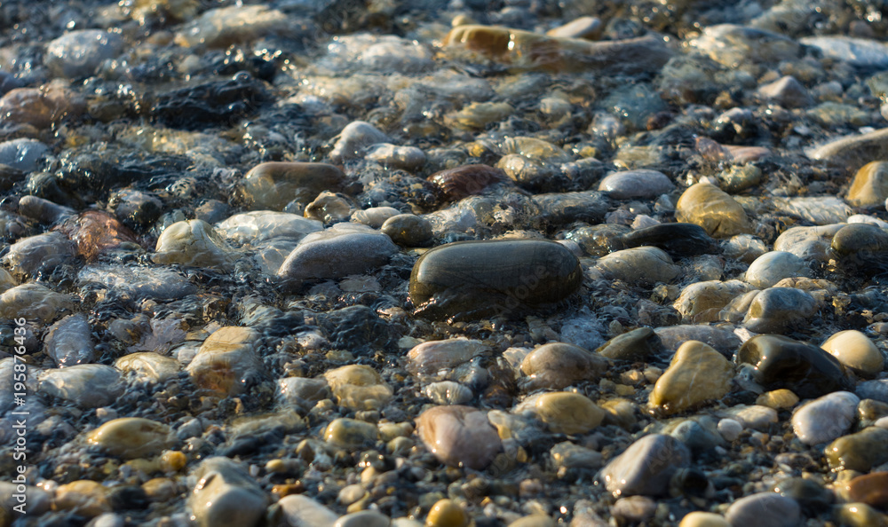 pebble stones on the sea beach, the rolling waves of the sea with foam pebble stones on the sea beach, the rolling waves of the sea with foam