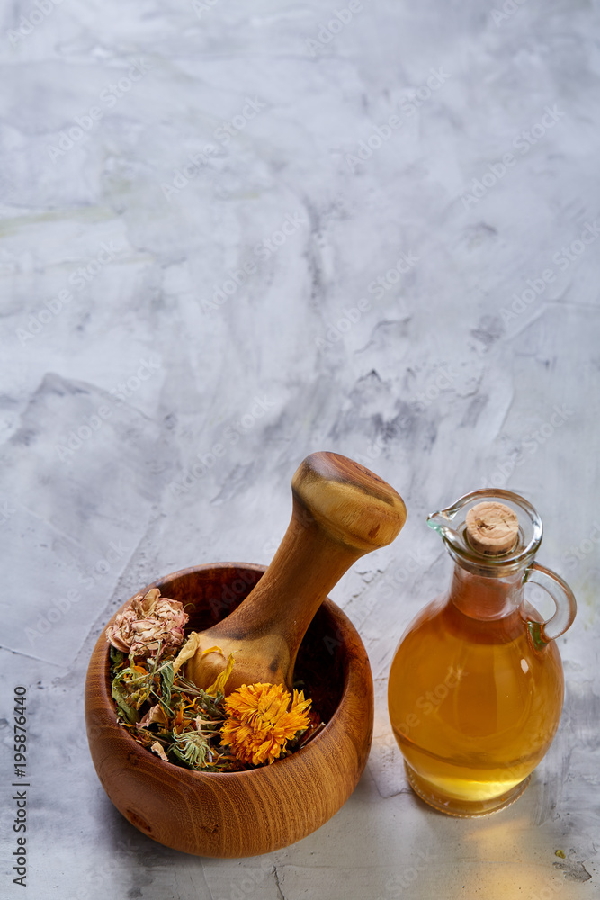 Spa still life with flowers in bowl and oil jars on light textured background, top view, close-up, selective focus Spa still life with flowers in bowl and oil jars on light textured background, top view, close-up, selective focus