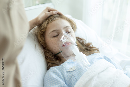 Girl sleeping with respiratory mask equipment in hospital. Healthcare and medical concept.