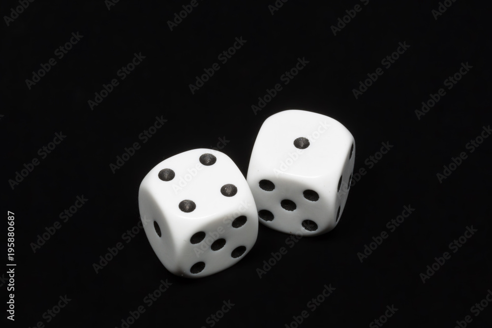The dices are cast - two dices showing four and one for a total of five on an isolated black background The dices are cast - two dices showing four and one for a total of five on an isolated black background