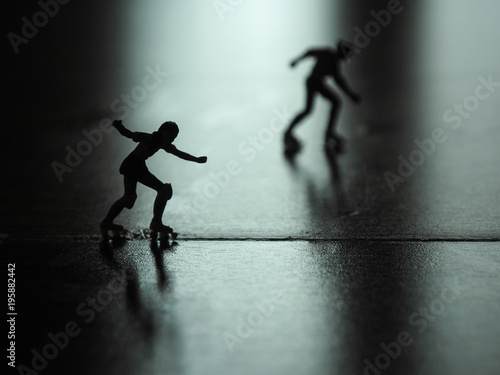 Silhouette miniature woman skating on the floor.