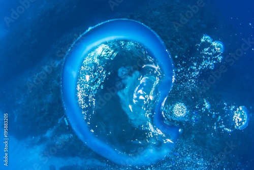 A bubble of air that has been exhaled from a scuba diver rises gently to the surface of the deep blue sea. On its journey the piece of gas changes shape before reaching the surface © drew