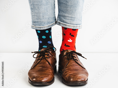 Male legs in bright, colorful socks and stylish, vintage shoes on a white background. Lifestyle, fashion, fun