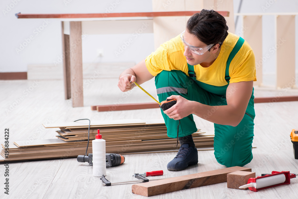 Contractor working on laminate wooden floor Contractor working on laminate wooden floor