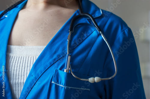doctor in blue uniform with stethoscope close-up