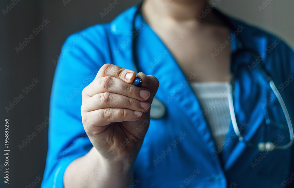 Fototapeta premium doctor in blue uniform holds the pen in the lens