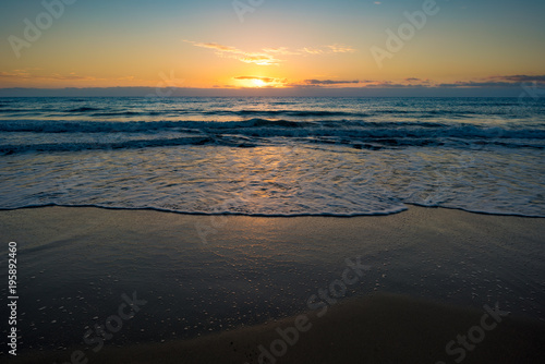  sunset or sunrise on the sea with a sandy beach. Calm sea at dusk