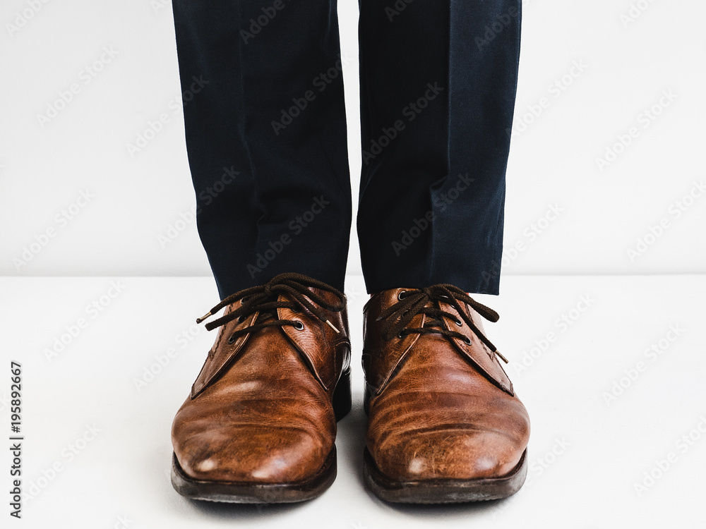 Stylish shoes and blue trousers on a white background