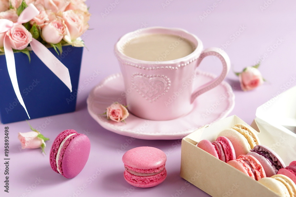 Beautiful holiday background. macaroons in pastel colors with bouquet of pink roses flowers on a pale purple background.Holiday background.copy Beautiful holiday background. macaroons in pastel colors with bouquet of pink roses flowers on a pale purple background.Holiday background.copy
