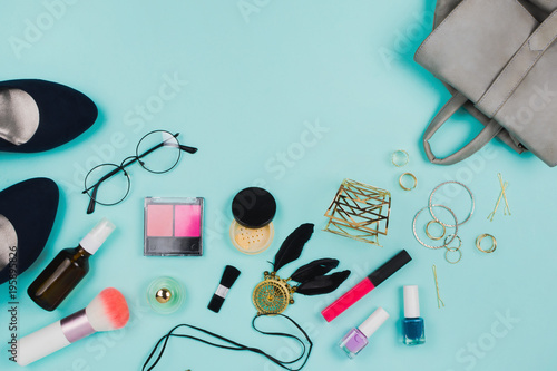 Beautiful fashion flatlay arrangement with various fashion accessories: glasses, cosmetics, jewelry, rings, shoes etc. Mint background. Concept of preparation. Copyspace