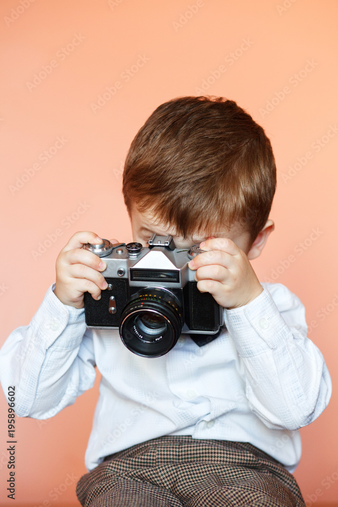Little boy with aged retro camera. Child with an old camera Little boy with aged retro camera. Child with an old camera