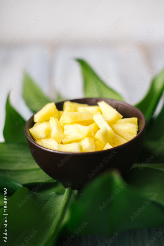 Sliced fresh pineapple in a bowl on the leaves Sliced fresh pineapple in a bowl on the leaves