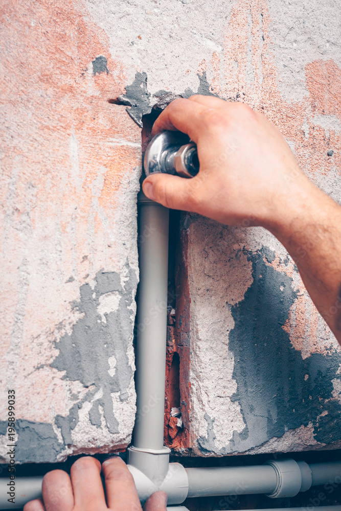 The worker carries out plumbing works in the house, mounts water pipes from polypropylene The worker carries out plumbing works in the house, mounts water pipes from polypropylene