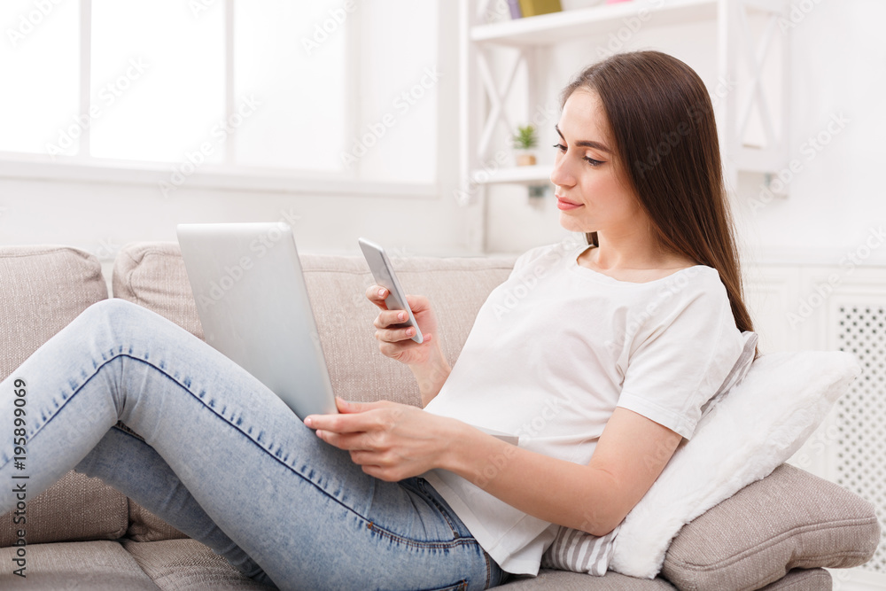 Young girl with a laptop messaging on mobile Young girl with a laptop messaging on mobile