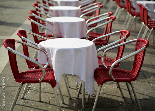 tables and red chairs in an alfresco cafe
