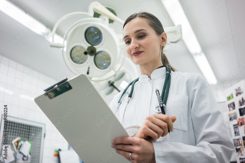 Doctor in Clinic Operation Theater with clipboard in hand Doctor in Clinic Operation Theater with clipboard in hand