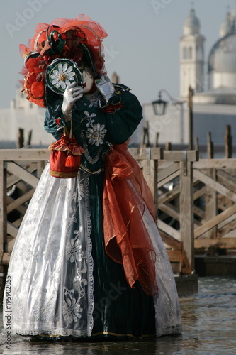  woman in beautiful red green and white masquerade dress and mask at the Venice carnival Italy © Tetiana
