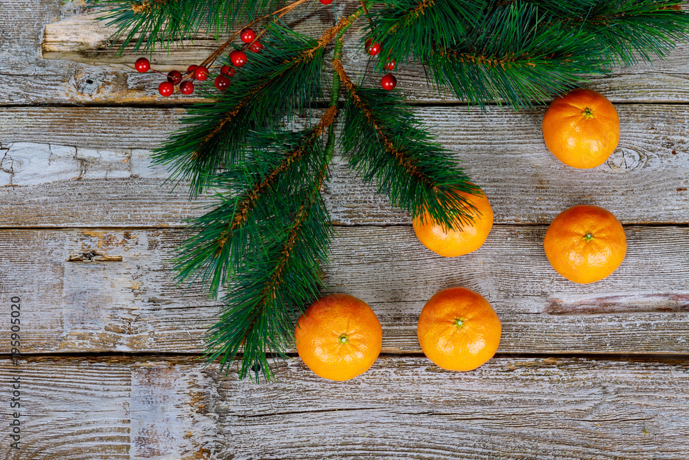 Christmas concept with Tangerines, Fir branches with spices on the old rustic wooden table. New year background. Selective focus. Christmas concept with Tangerines, Fir branches with spices on the old rustic wooden table. New year background. Selective focus.