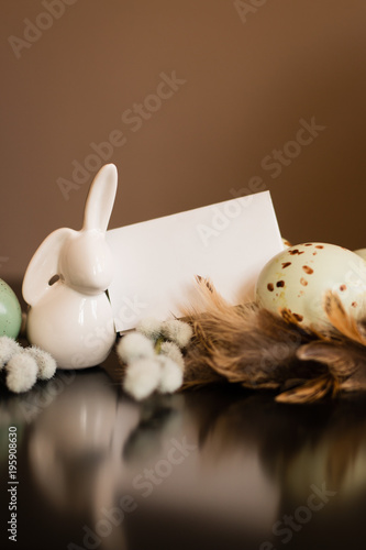 Small white rabbit figurine with easter eggs photo