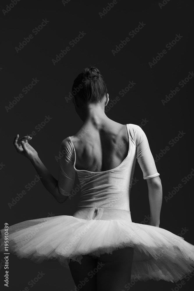 Naklejka premium Young beautiful ballerina is posing in studio