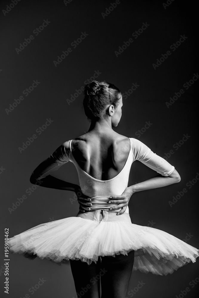 Young beautiful ballerina is posing in studio