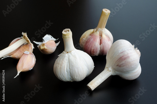 heads of garlic over black