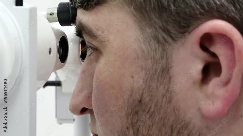 Video Stock Patient in ophthalmology clinic. Man looks in synoptophore ophthalmic instrument