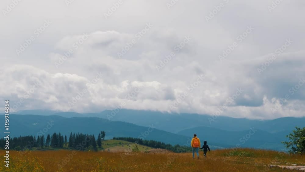 Mother with son walking in cloudy weather in mountains Mother with son walking in cloudy weather in mountains