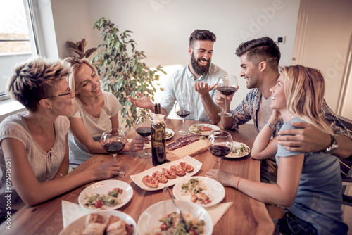 Group of friends enjoying meal at home together