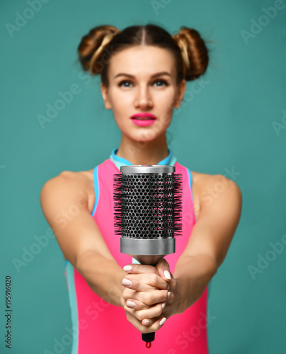 happy fashion brunette woman singing with big hair comb brush on modern blue mint