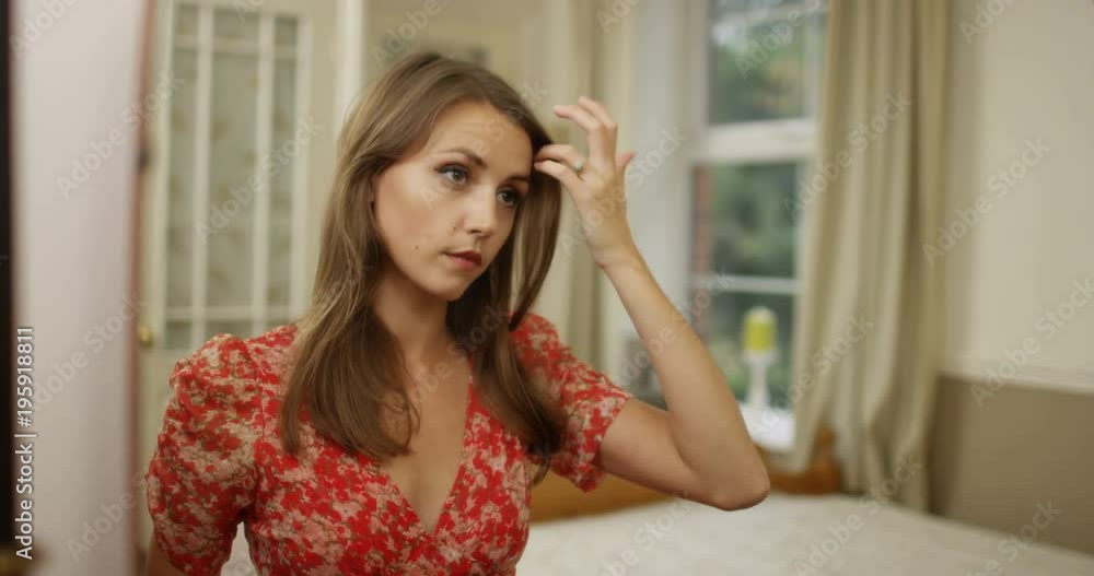 4K Beautiful young woman checking her appearance in the mirror. Slow motion. 4K Beautiful young woman checking her appearance in the mirror. Slow motion.