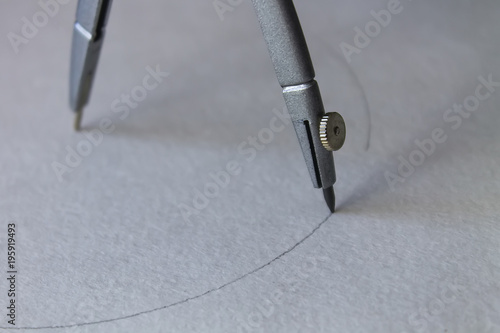 compasses draw a circle on a sheet of paper