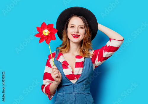 girl in hat and jeans clothes with pinwheel poy