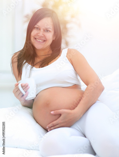 happy pregnant woman sitting in the living room