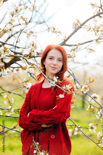 girl in red clothes in blossom cherry garden