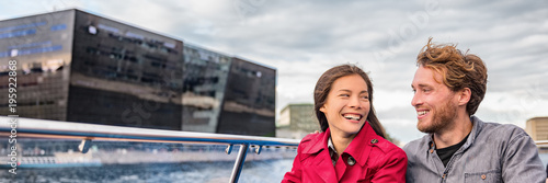 Photography Copenhagen tourists couple on city boat cruise tour of the black diamond Royal library, famous architecture building, Denmark, Europe travel