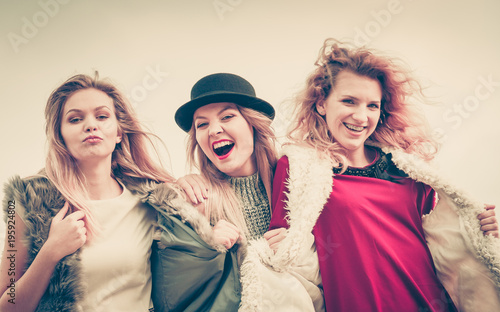 Three fashionable woman against sky