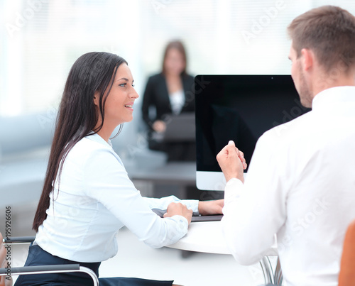 two successful employee talking sitting behind a Desk