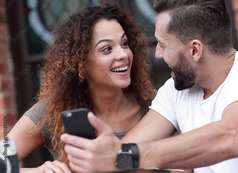 Portrait of a young couple sitting down at a cafe terrace Portrait of a young couple sitting down at a cafe terrace