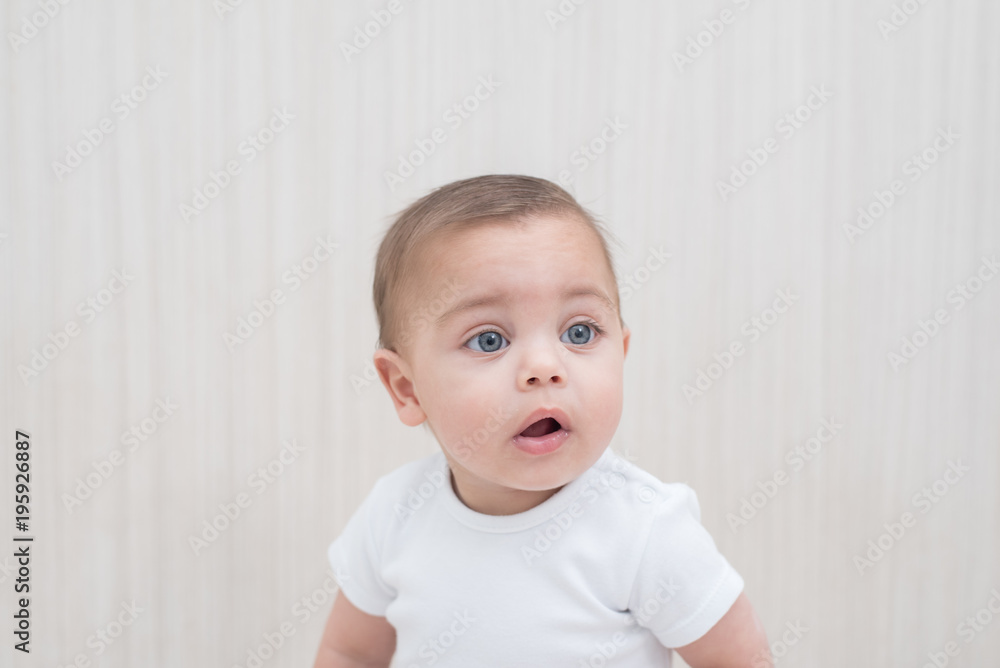 Blue-eyed baby boy on white wooden background