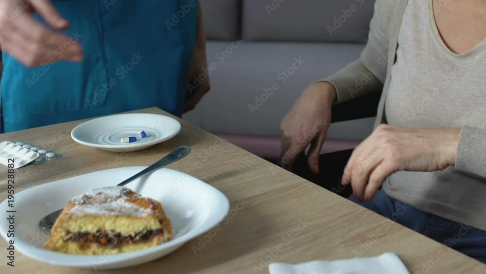 Woman refusing to eat pie, nurse trying to persuade, old age digestion problem Woman refusing to eat pie, nurse trying to persuade, old age digestion problem