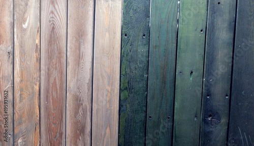 The texture of the old fence, painted in pink and dark green colors 