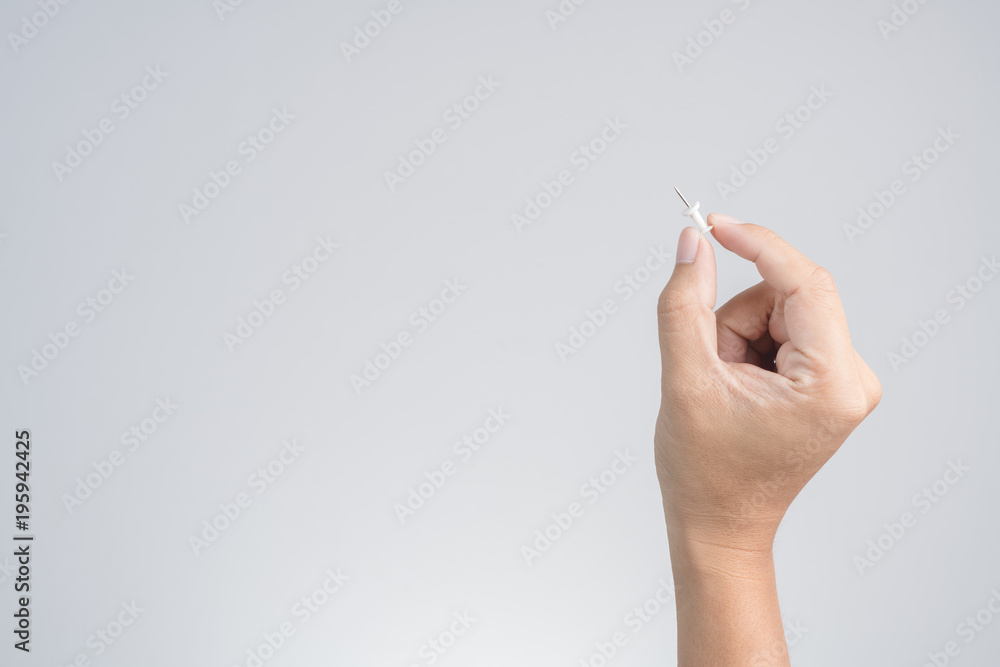 Hand holding push pin for paper or board Hand holding push pin for paper or board