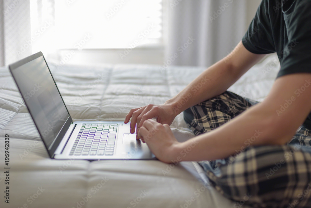 Naklejka premium College student working on laptop on bed