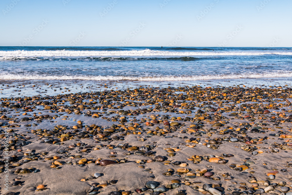 South Carlsbad State Beach in San Diego, California with colorful stones covering the beach.