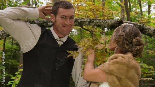 bride and groom having fun kissing in the woods 4k photo