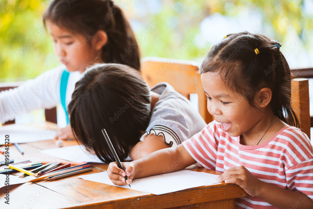 Group of asian children drawing and painting with crayon together with fun Group of asian children drawing and painting with crayon together with fun