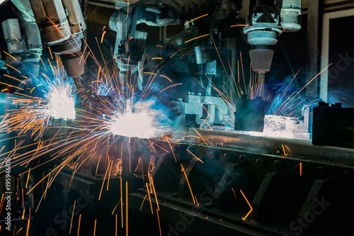 Industrial welding robots are welding in car factory